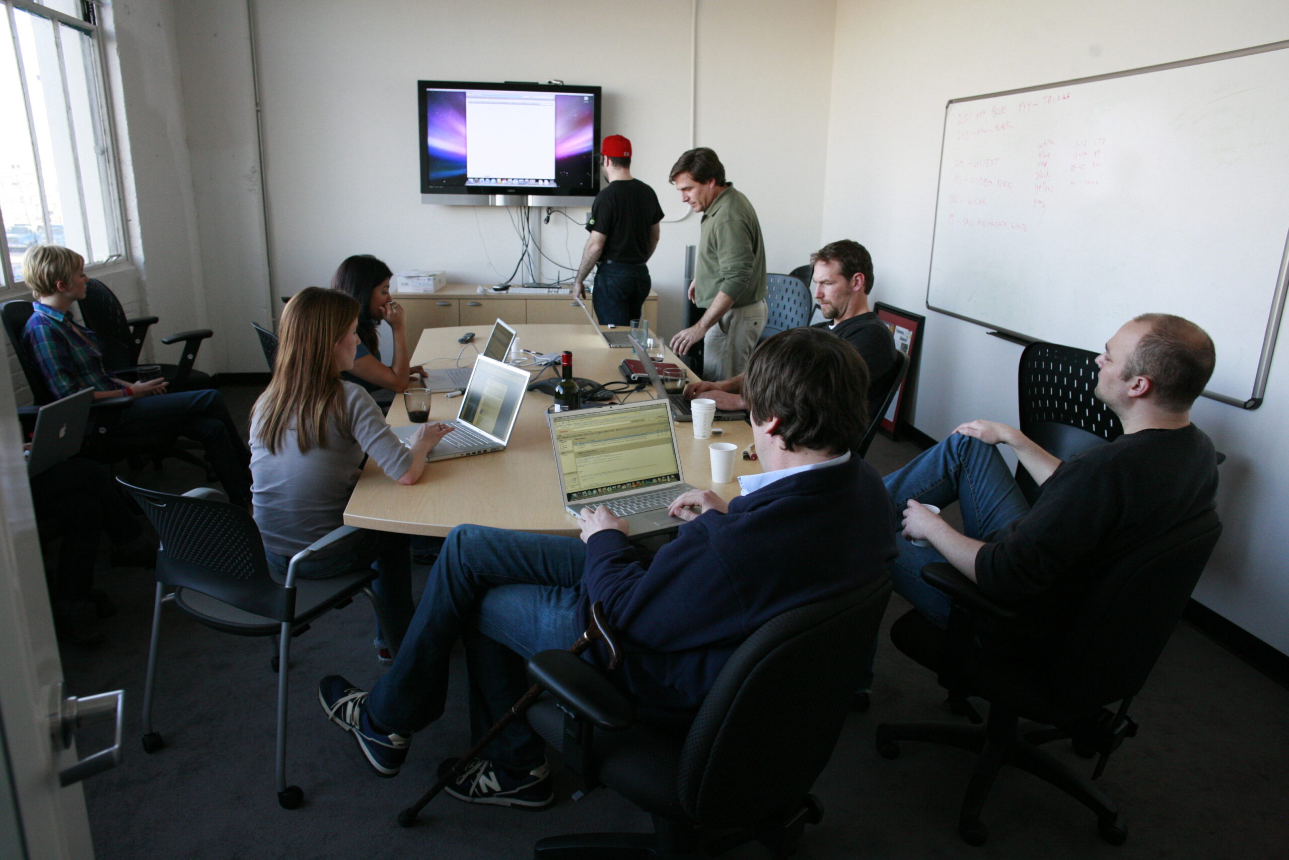 Team meeting with laptops in an office, representing WordPress website support and maintenance planning for a small business