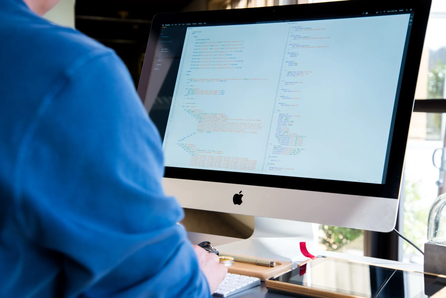 Web developer coding a custom WordPress theme on an iMac