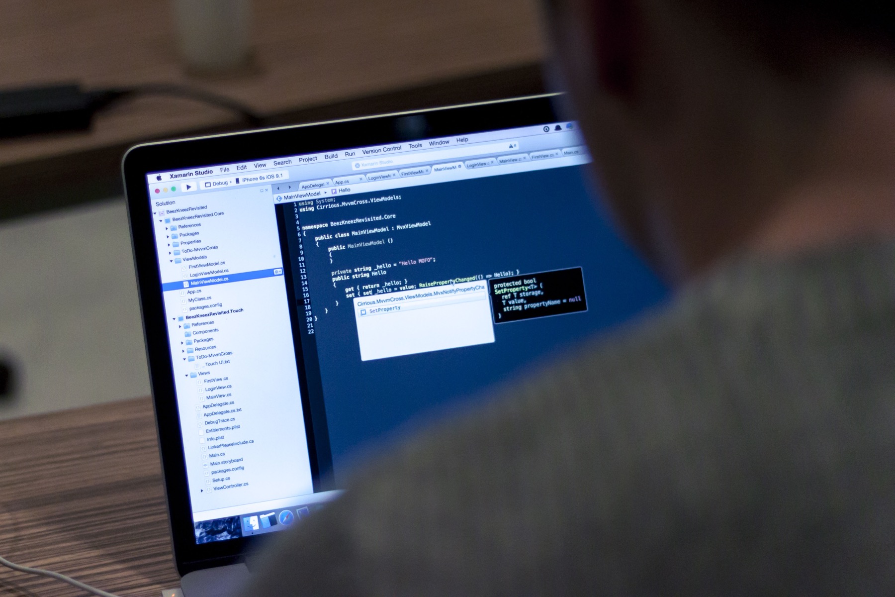 Software developer working with source code on a laptop