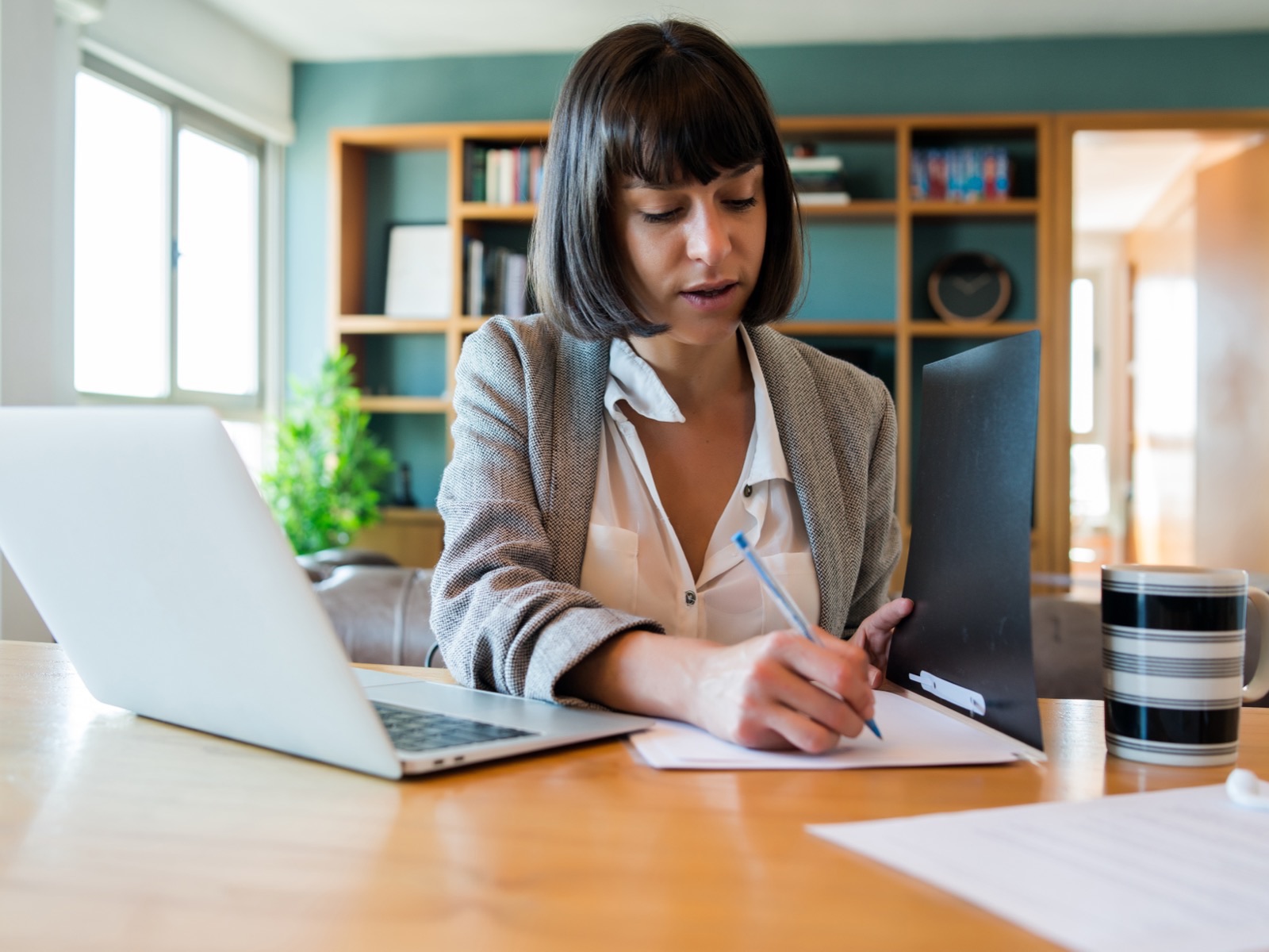 Business owner at her desk drafting the privacy policy of her website next to her laptop
